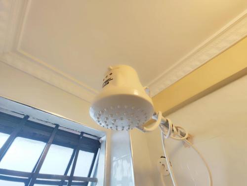 a white light hanging from a ceiling with a window at The Little Haven - Ample Parking, Views & Netflix in Kikuyu