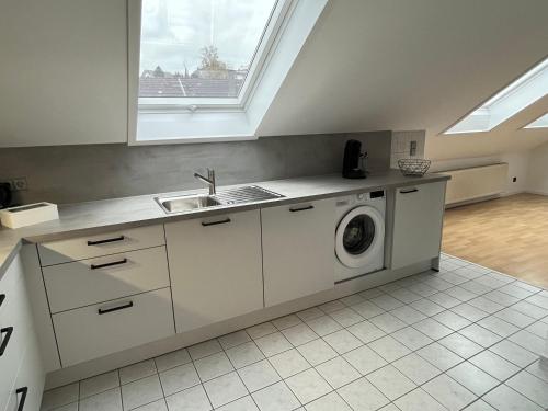 una cucina con lavandino e lavatrice di Ferienwohnung Mooi a Kraichtal