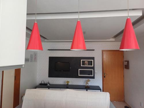 two red lights hanging from the ceiling in a living room at Apartamento Luxo em Vespasiano in Vespasiano