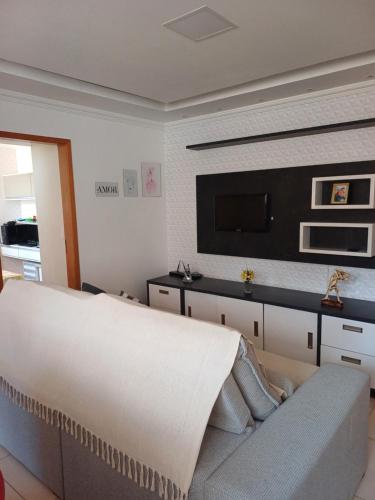 a living room with a couch and a flat screen tv at Apartamento Luxo em Vespasiano in Vespasiano