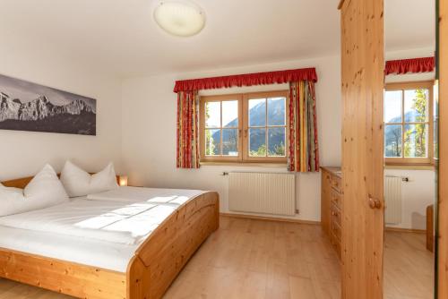 a bedroom with a wooden bed and a window at Haus Diamant by Schladming-Appartements in Schladming