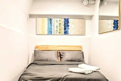1 dormitorio pequeño con 1 cama con 2 almohadas en ENTIRE Garden Apt-Private Parking+Central Location en Vancouver