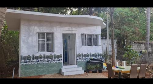 a small white house with a table and chairs at Lotus in Kanyakumari