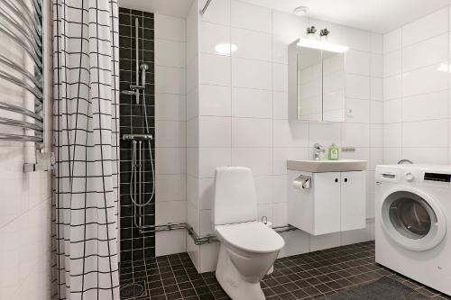 La salle de bains est pourvue de toilettes et d'un lave-linge. dans l'établissement Guestly Homes - 3BR City Charm, à Piteå