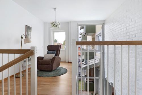 a living room with a staircase and a chair at Guestly Homes - 3BR City Charm in Piteå