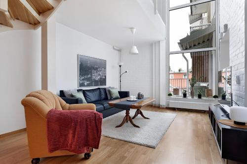 a living room with a couch and a table at Guestly Homes - 3BR City Charm in Piteå