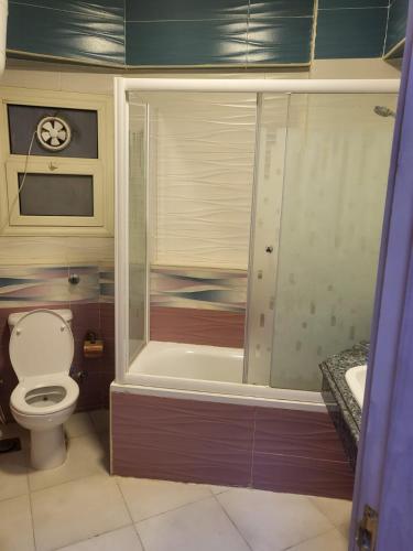 ein Badezimmer mit einer Dusche, einem WC und einer Badewanne in der Unterkunft دوبلكس فى السياحية السادسة in Madinat as-Sadis min Uktubar