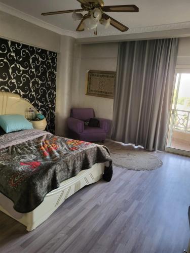 ein Schlafzimmer mit Bett und Deckenventilator in der Unterkunft دوبلكس فى السياحية السادسة in Madinat as-Sadis min Uktubar