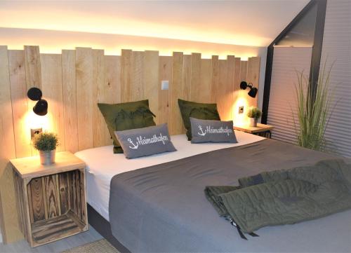 a bedroom with two beds and a wooden wall at Beach House Seebude in Büsum