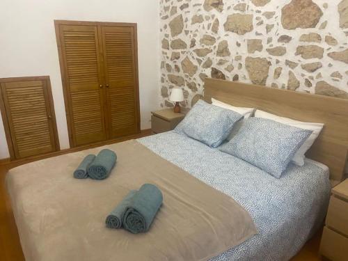 a bedroom with a bed with two blue towels on it at Casa do Lago - Villas de Campo in Ferreira do Zêzere