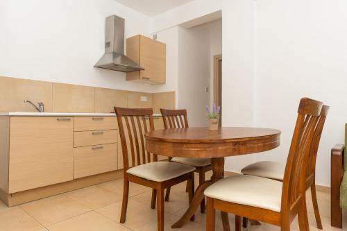 a kitchen with a wooden table and chairs at Flora Hotel Apartments in Protaras