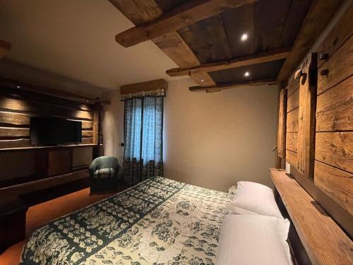 a bedroom with a bed and a tv on a wall at Hotel Milleluci in Aosta