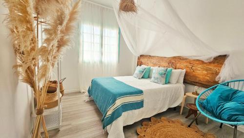 a bedroom with a bed with blue sheets and a window at Paraíso Las Galanas 2ROOMS in San Sebastián de la Gomera