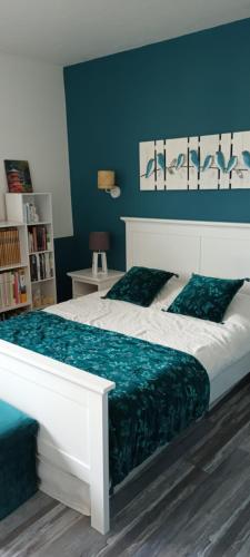 een slaapkamer met een wit bed en een blauwe muur bij Chambre proximité Paris, site JO in Saint-Thibault-des-Vignes