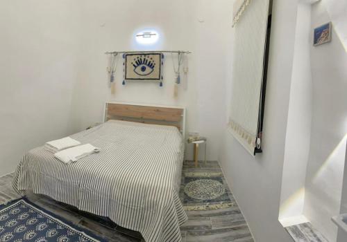 a small room with a bed and a clock on the wall at shym_apart in Shymkent