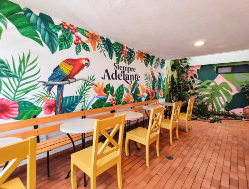 un restaurante con mesa, sillas y una pared colorida en Zamia Hostel, en Bucaramanga