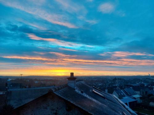 a sunset on top of a roof of a building at Chambre cosy de Bonabry in Fougères