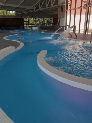 une grande piscine avec de l'eau bleue dans un immeuble dans l'établissement Charmante maison, à Vitry-le-François