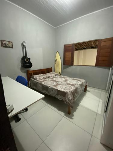 a bedroom with a bed and a surfboard in it at Agradável Casa de praia no Francês in Marechal Deodoro