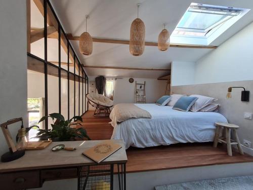 a bedroom with a bed and a desk and a window at Le Mas du Castellas 5* in Le Thor