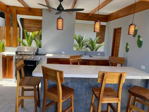 a kitchen with a large island with wooden chairs at Casa Gravel in Pochote