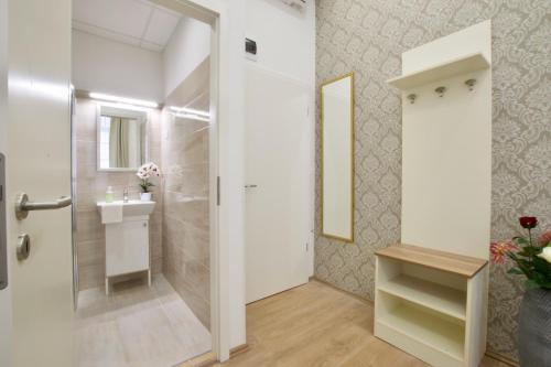 y baño con ducha a ras de suelo y lavamanos. en St. King 11 Apartments en Budapest