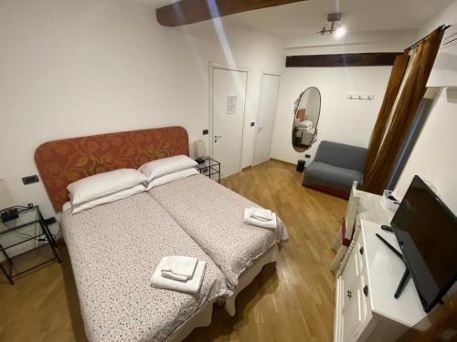 ボローニャにあるB&B and Home La Piazzetta della Pioggiaのベッドと薄型テレビのある寝室
