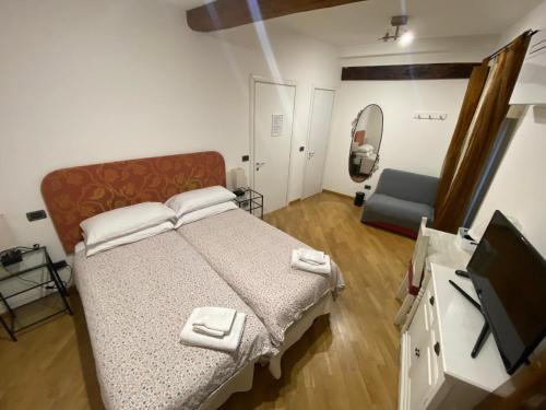 1 dormitorio con 1 cama y TV de pantalla plana en B&B La Piazzetta della Pioggia, en Bolonia