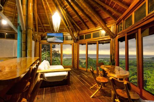 a room with a table and chairs and windows at Cabañas Cochapunko I Espectacular vista 360 in Ayampe