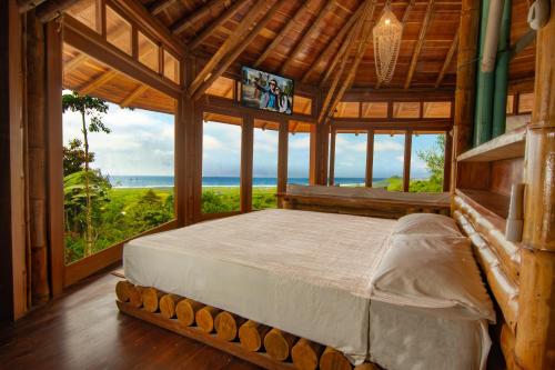 a bedroom with a bed with a view of the ocean at Cabañas Cochapunko I Espectacular vista 360 in Ayampe