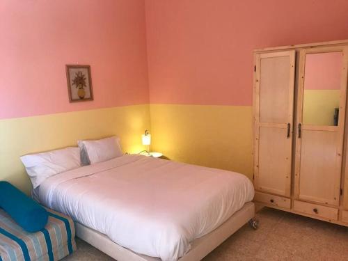 a bedroom with a large white bed and a cabinet at Dar Medina Tozeur in Tozeur