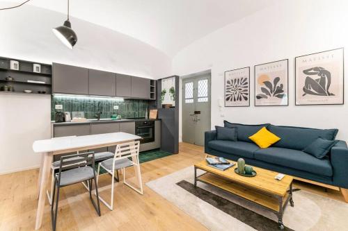 a living room with a blue couch and a table at Modern Loft Trastevere in Rome