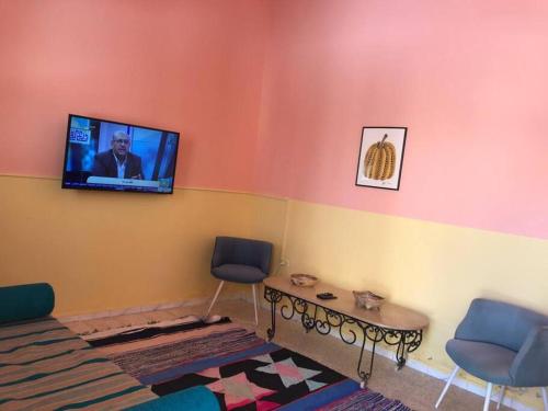 a living room with a tv on the wall at Dar Medina Tozeur in Tozeur