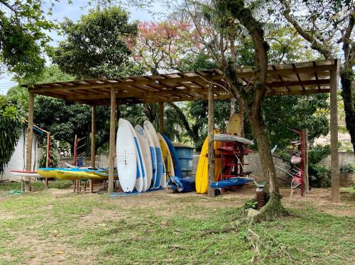 a group of surfboards lined up under a wooden shelter at Porto Grande Hotel & Convention in São Sebastião