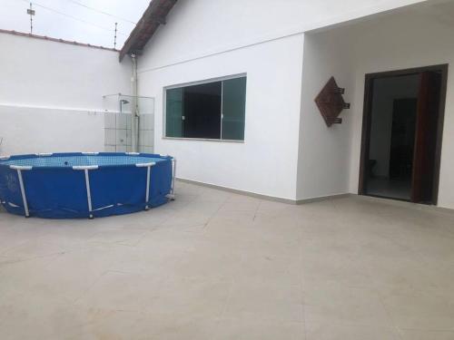 Cette chambre dispose d'une grande baignoire bleue dans un mur blanc. dans l'établissement Pertinho da Praia Ar condicionado na Sala e em todos os Quartos - Venha curtir os Shows no Viva Verão Peruíbe, à Peruíbe