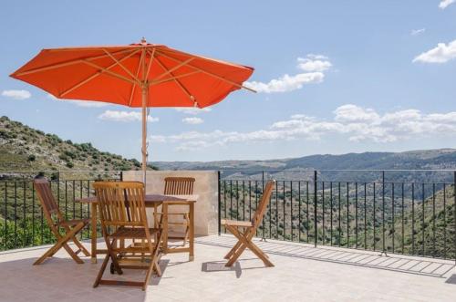 a table and chairs with an umbrella on a patio at Villa Dolce Valle in Ragusa