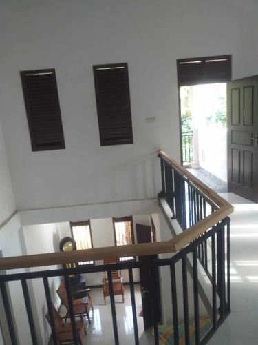 Habitación con una escalera con sillas y ventanas. en Hesali villa, en Ambalangoda