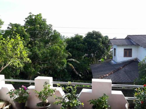 una cerca blanca con macetas delante de una casa en Hesali villa, en Ambalangoda