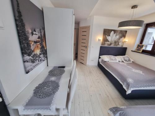 een kleine slaapkamer met een bed en een tafel bij Willa Pod Szymoszkową in Zakopane