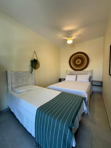 two beds sitting next to each other in a room at Apartamento na praia Garopaba San Pietro Sc loft 102 in Garopaba