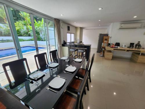 a dining room with a long table and chairs at Rock Valley Private Pool Villa 3 Bedroom Phuket town in Ban Bang Khu