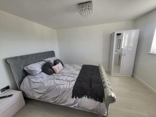 a bed in a white room with a pillow on it at Brooke View Barns No 1 in Norwich
