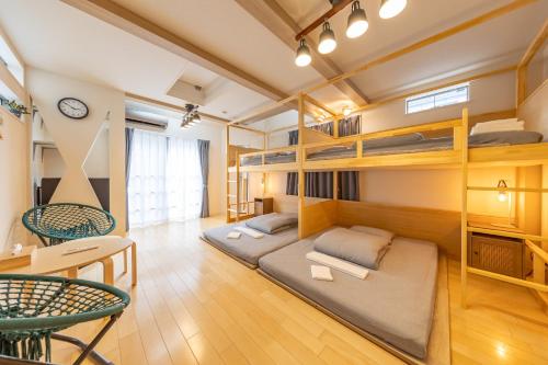 a room with bunk beds and a table and chairs at HAN'S EBISU - Shibuya - Entire House for Max 10 ppl in Tokyo