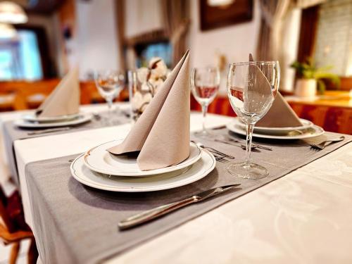 a table with plates and wine glasses and napkins at Landgasthaus Sternen in Kehl am Rhein