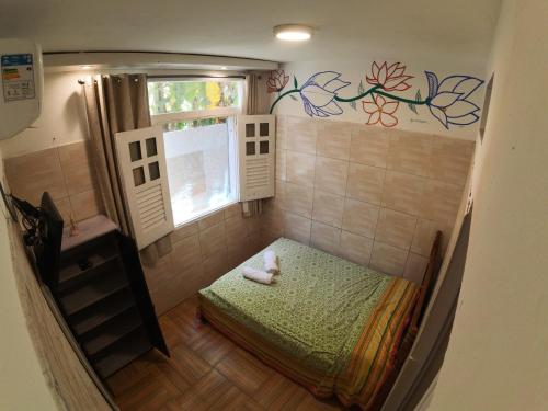 um pequeno quarto com uma cama e uma janela em Kitnet Perto da Primeira Praia em Morro de São Paulo