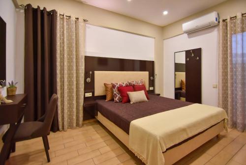 1 dormitorio con cama, escritorio y ventana en A Cozy Eco Villa by the Sea, en Gouves