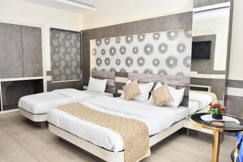 Habitación de hotel con 2 camas y mesa en Hotel The Heera Divine, en Kānpur