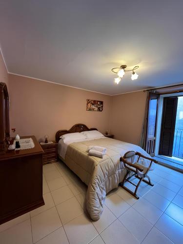 a bedroom with a bed and a desk and a window at Dimora dell'Etna in Randazzo