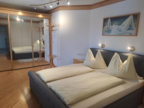 un grande letto in una stanza con specchio di Ferienhaus Berger a Aigen im Ennstal