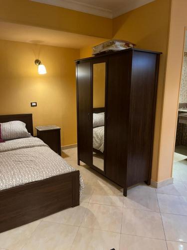 a bedroom with a bed and a cabinet with a mirror at Heliopolis Rock Residence in Cairo